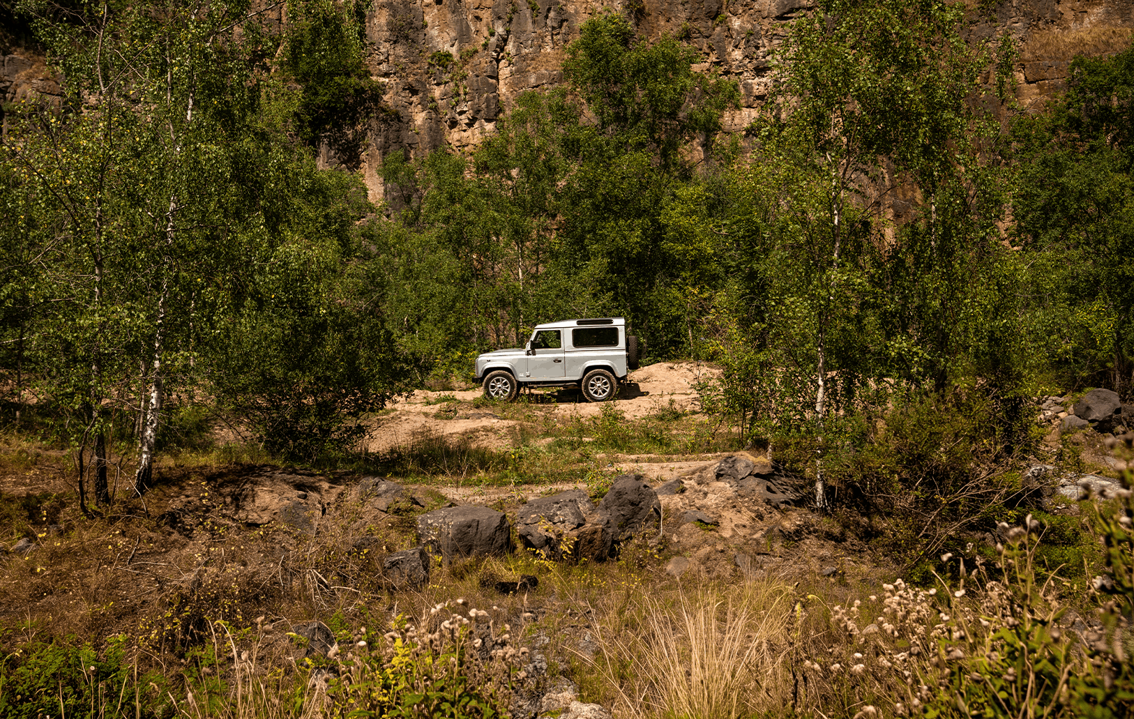 Soft Top Classic Defender on sandy ground.