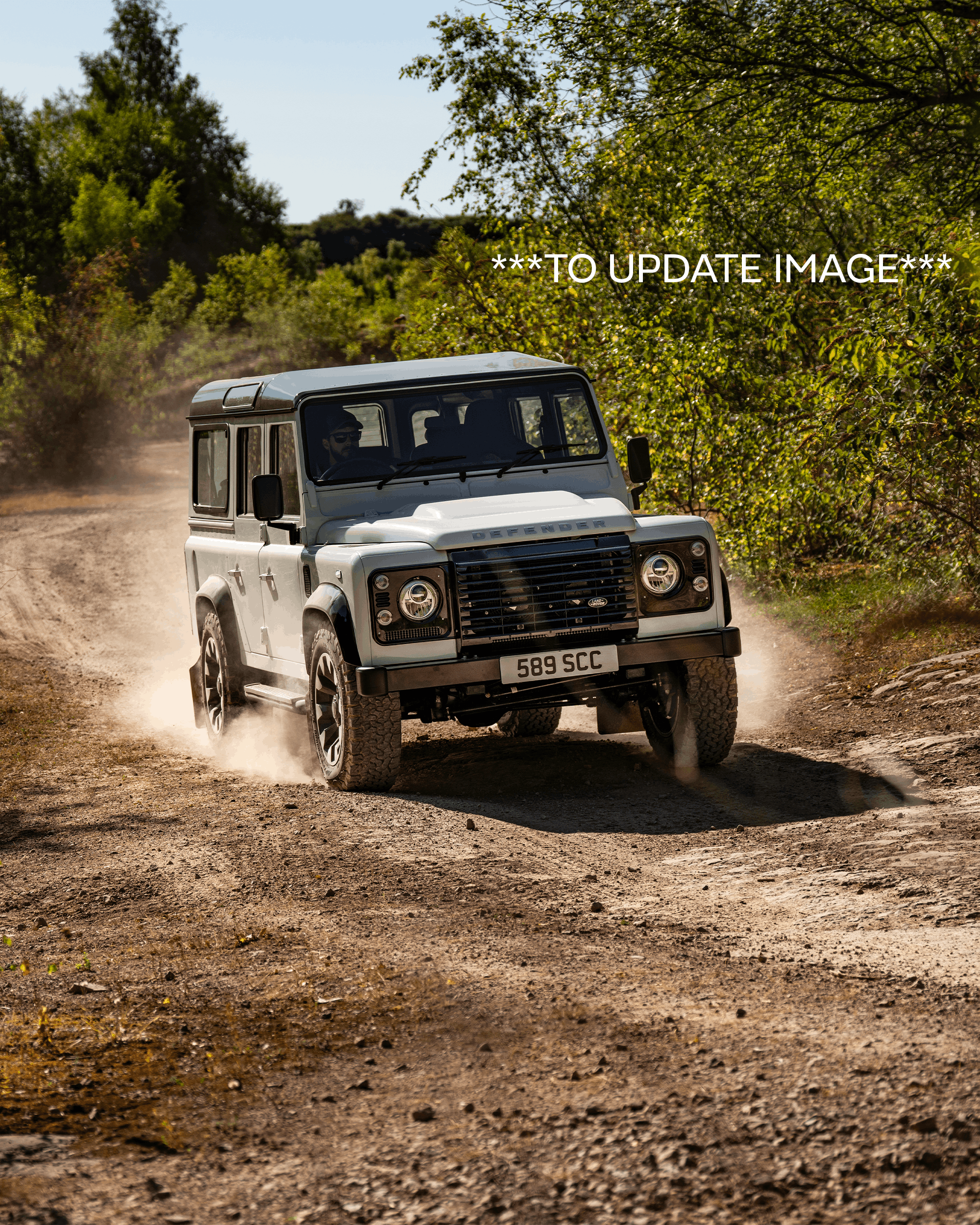 Front view of a black Defender with visible grille, headlights, and side mirror.
