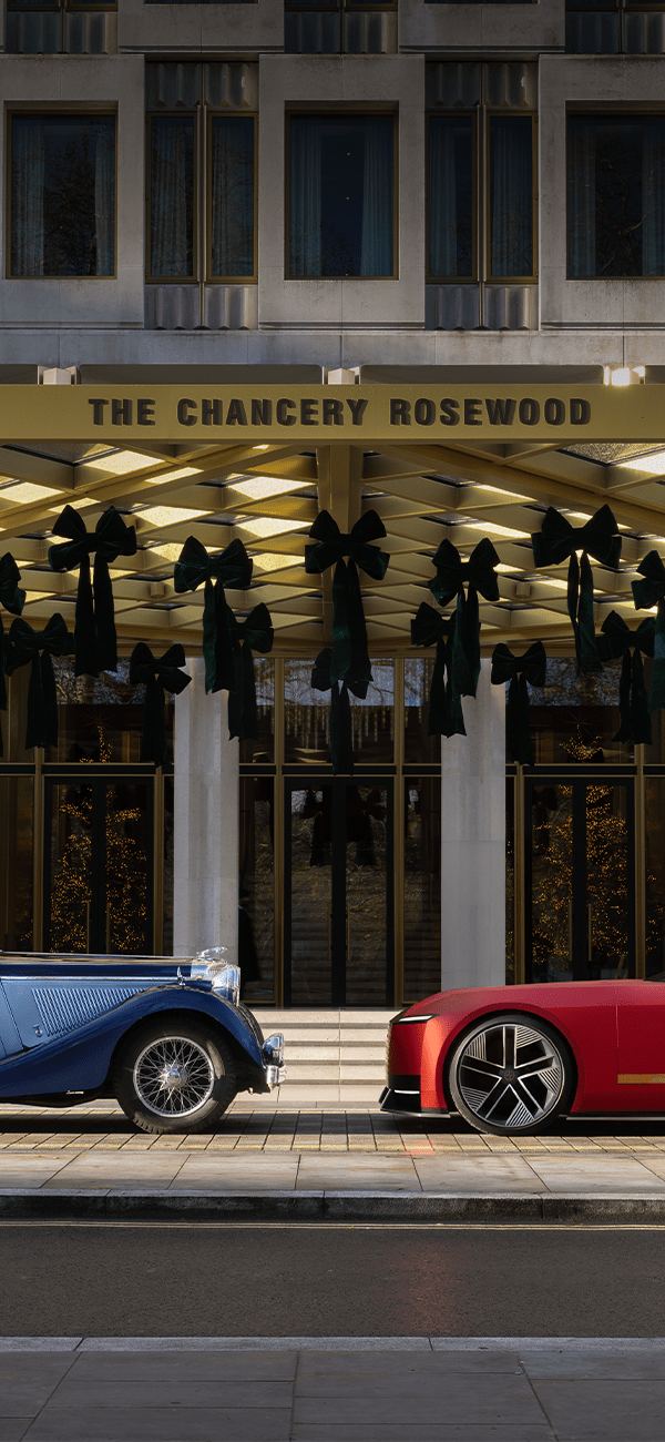 Front right tire of a black Defender in a shadowed concrete setting.