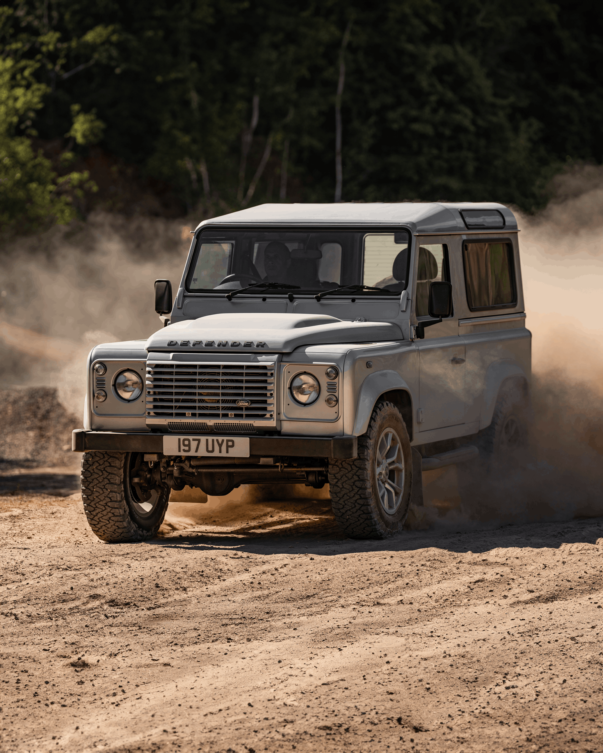 Front view of a black Defender with visible grille, headlights, and side mirror.